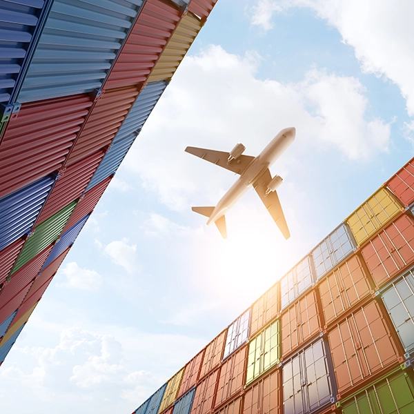 Un aereo sorvola un polo logistico con container