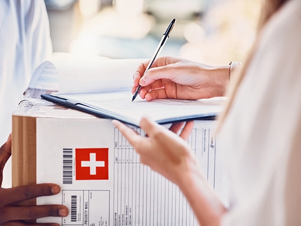 Un corriere consegna medicinali ad una farmacista 