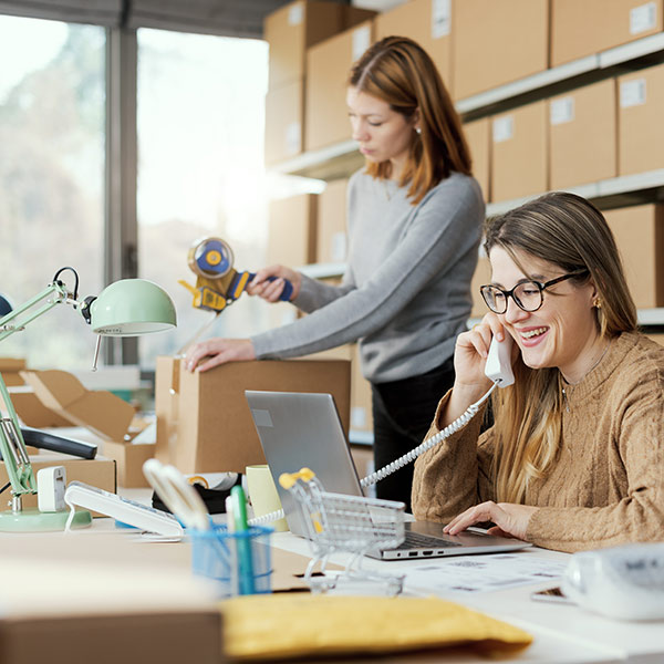 Due dipendenti lavorano all’inscatolamento di merci