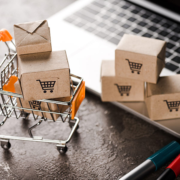 Scatole e carrello in miniatura sopra un computer